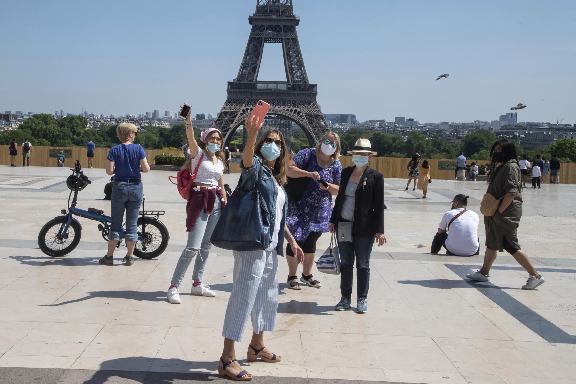 Visitors take a selfie at the Eiffel Tower on Sunday.