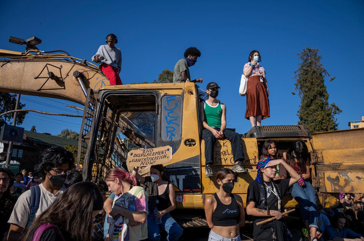 People stand on and around a heavy piece of machinery.