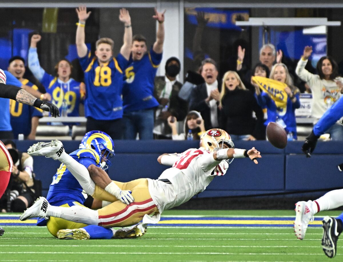 Aaron Donald tackles 49ers' Jimmy Garoppolo, who throws in desperation. The pass was intercepted to seal the Rams' win.