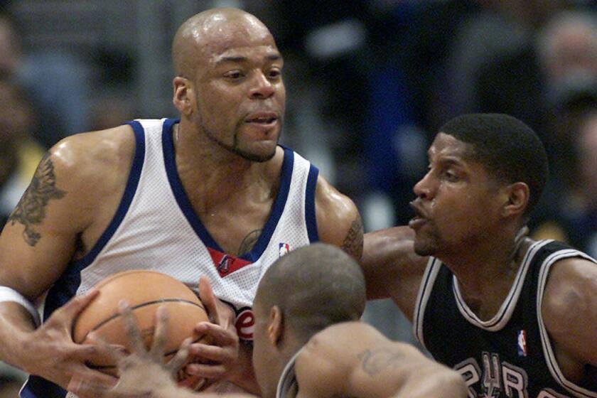 Former Clipper Sean Rooks fends off San Antonio Spurs defenders during a game on April 7, 2001. Rooks passed away on Tuesday. He was 46.
