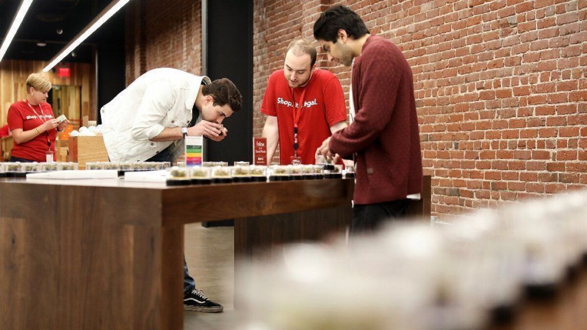 MedMen sales associate Cole Mercier, center, helps Adam Tantawi, left, and Raj Idnani, both visiting from New York, shop for cannabis at MedMen's downtown L.A. location.