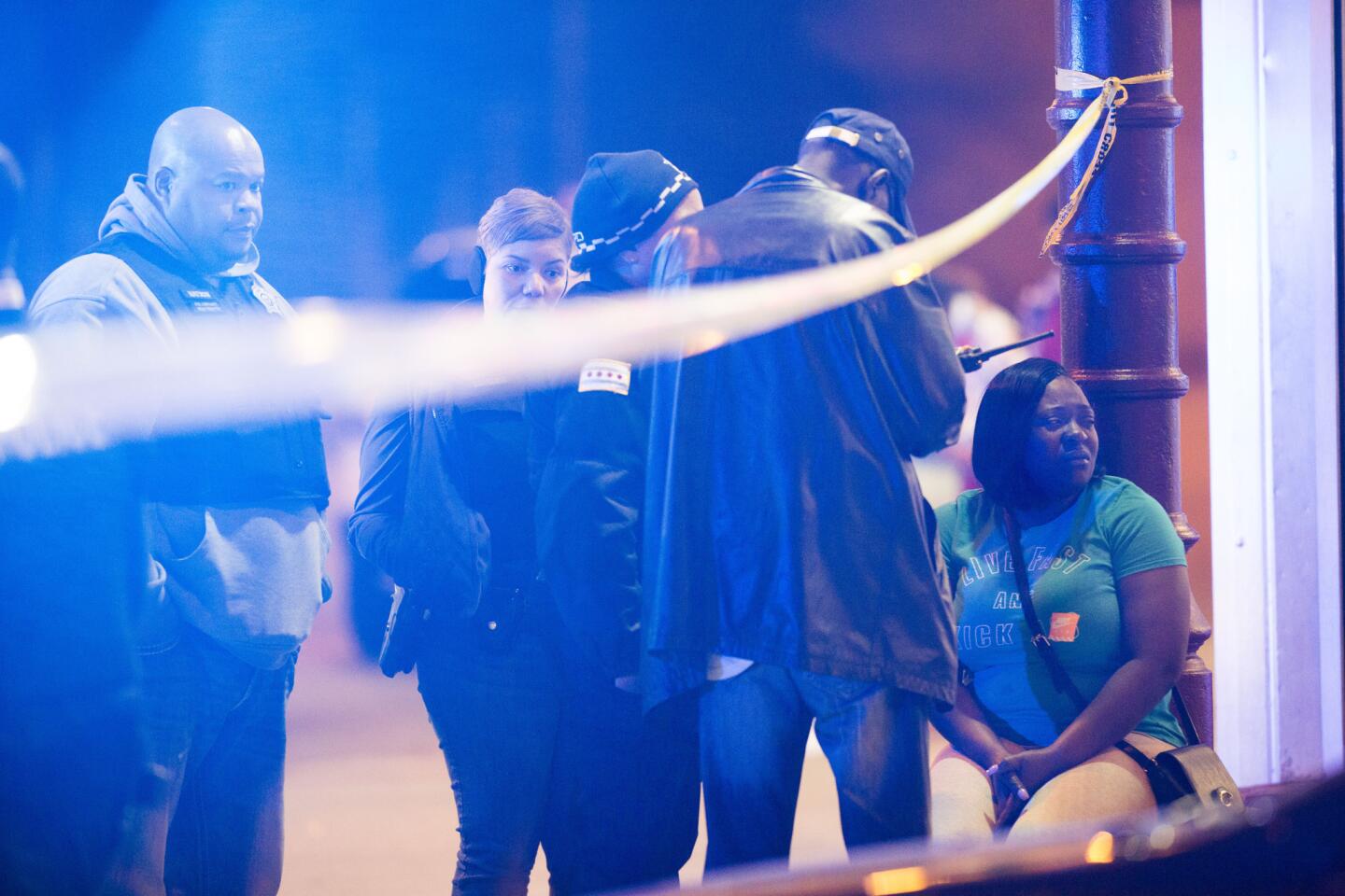 Chicago police talk with a woman after a fatal shooting near South State Street and West Garfield Boulevard on May 21, 2016.
