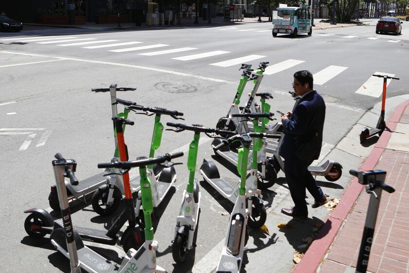 SAN DIEGO, CA - MAY 12: Bird and Lime scooters were lined up on Broadway in downtown San Diego on Thursday May 12, 2022. (K.C. Alfred / The San Diego Union-Tribune)