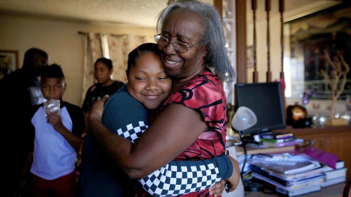 Ola Tanner hugs her great granddaughter, Alani Hayes, 11, in the kitchen of her Willowbrook home.