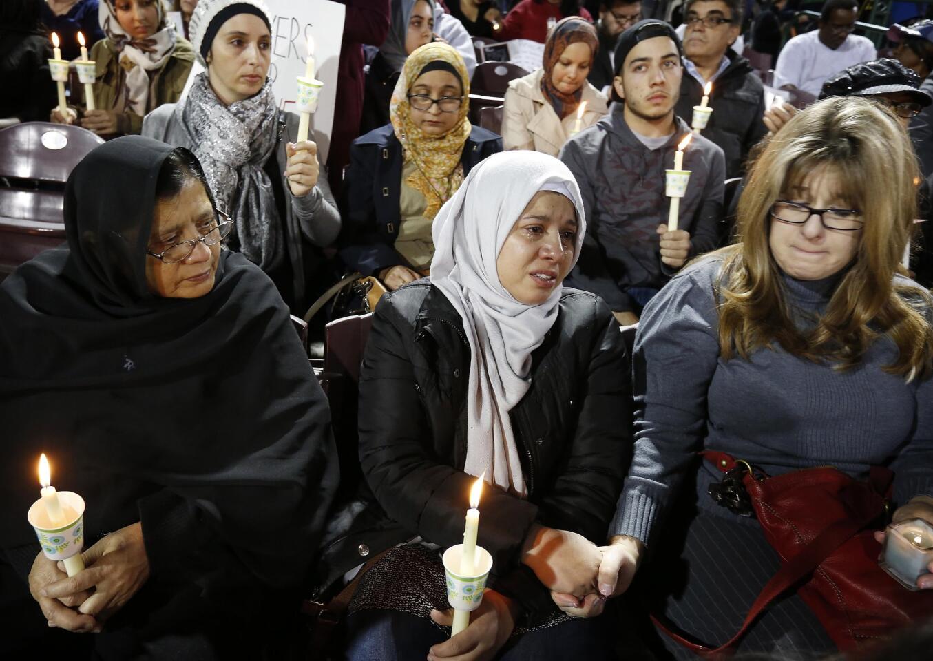 Amy Mahmood, right, holds hands with a woman named Shenaz during a Dec. 3, 2015, vigil at San Manuel Stadium in San Bernardino, Calif.