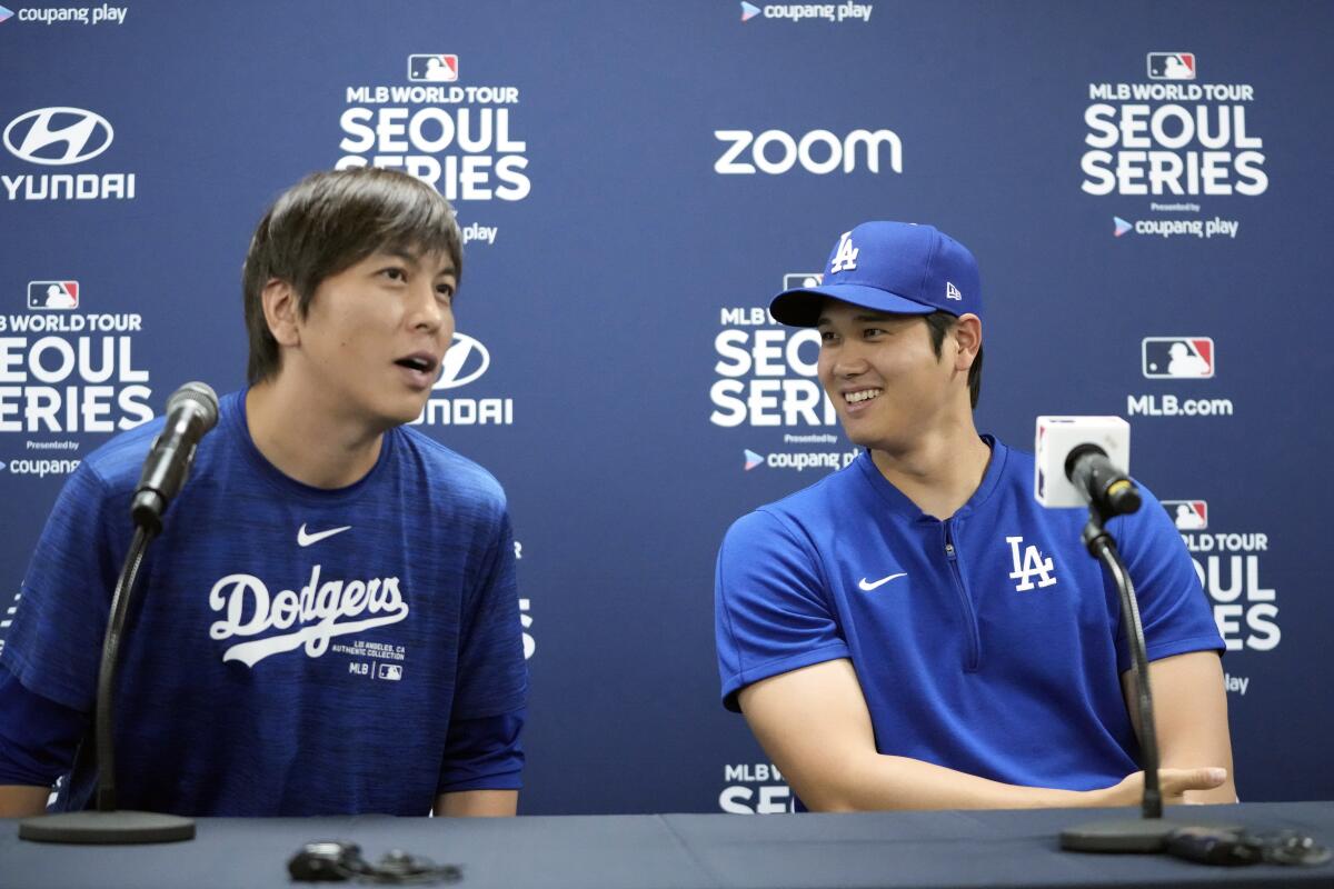 Dodgers superstar Shohei Ohtani, right, and his former interpreter Ippei Mizuhara sit beside each other at a news conference.