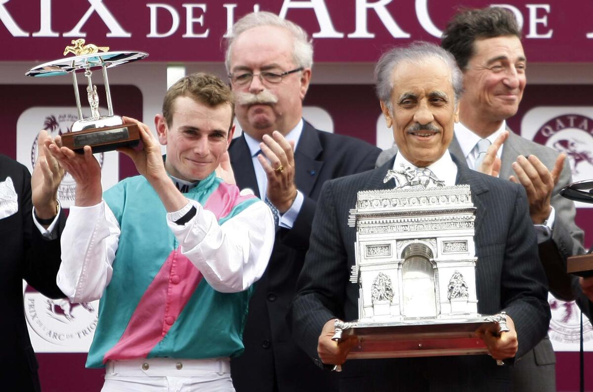 Khalid Abdullah, left, celebrates with jockey Ryan Lee Moore after winning the Prix de l'Arc de Triomphe.