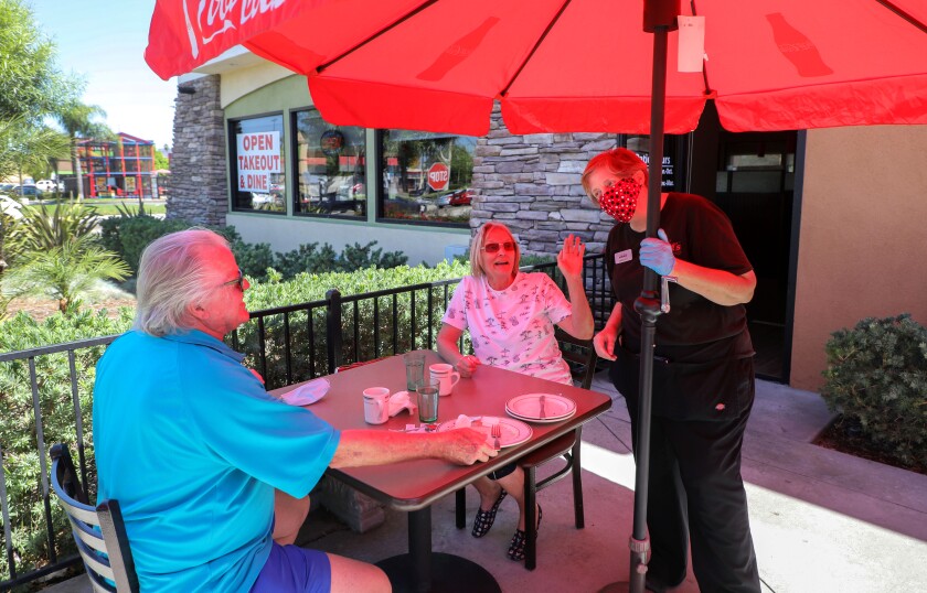 Waitress Kimberly Forrest takes care of customers Larry and Connie Clay.