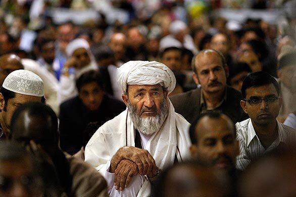 Farooqi Fazal, of Huntington Beach, center, and fellow Muslims listen to the the Eid al-Adha sermon at the Anaheim Convention Center. The holiday is among the most important Muslim traditions and follows the annual Islamic pilgrimage.