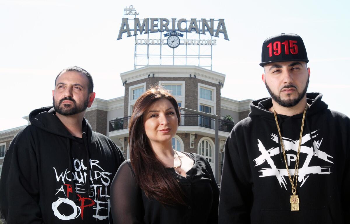 Alex Kodagolian, Tina Chuldzhyan and Armin Hariri, a rapper also known by his stage name "R-Mean," stand across the street from the Americana at Brand after they were told to stop displaying T-shirts referencing the Armenian Genocide on Thursday, March 12, 2015.