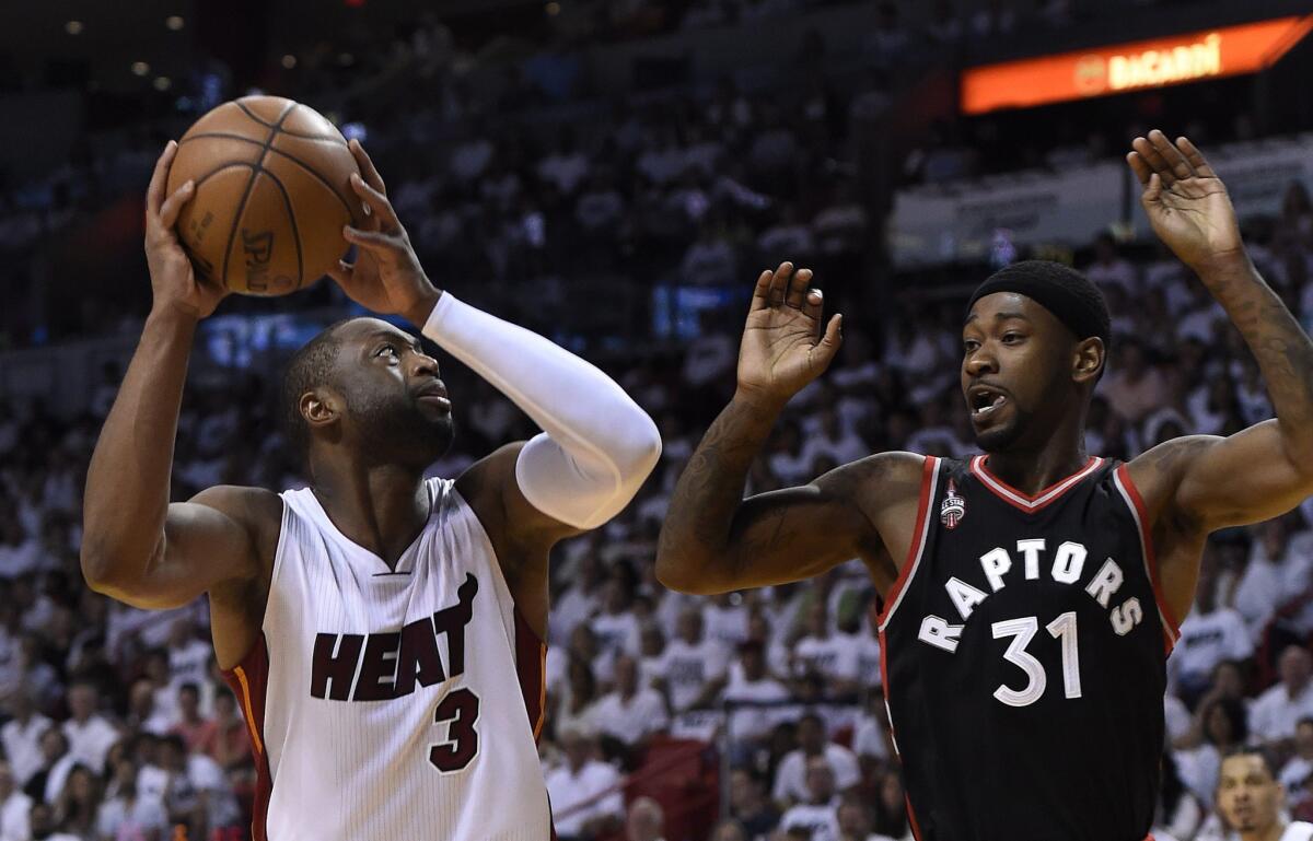 Miami's Dwyane Wade is defended by Toronto's Terrance Ross.