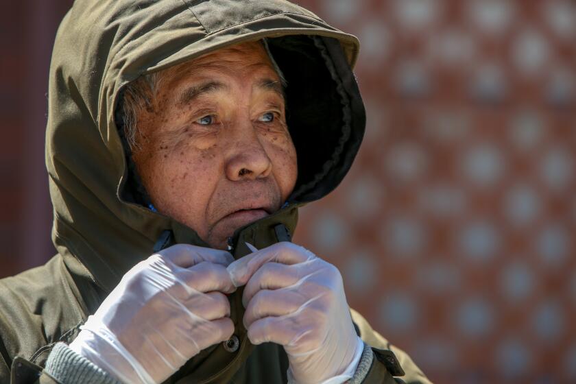 LOS ANGELES, CA-MARCH 22, 2020: Ben Barcelona zips his jacket to take a walk from his to his daughter's apartment on his 81st birthday on March 22, 2020 in Los Angeles, California. He wears protective gloves and feels his jacket that covers his mouth both lessen the chance of contracting the coronavirus. (Photo By Dania Maxwell / Los Angeles Times)