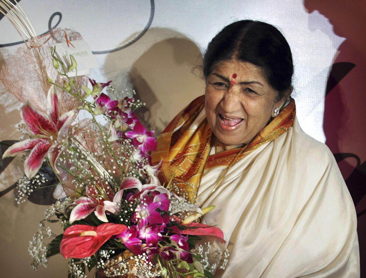 FILE- Singer Lata Mangeshkar laughs at the launch of her hindi music album 'Saadgi' or Simplicity, on World Music Day, in Mumbai, India, Thursday, June 21, 2007. Lata Mangeshkar, legendary Indian singer with a voice recognized by a billion people in South Asia, has died at 92. (AP Photo/Rajesh Nirgude, File)(AP Photo/Rajesh Nirgude, file)