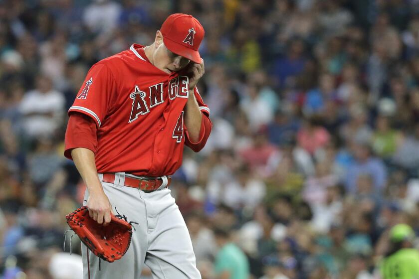 Angels starting pitcher Garrett Richards walks off the field after giving up 12 hits-- tying a career high -- to the Mariners .