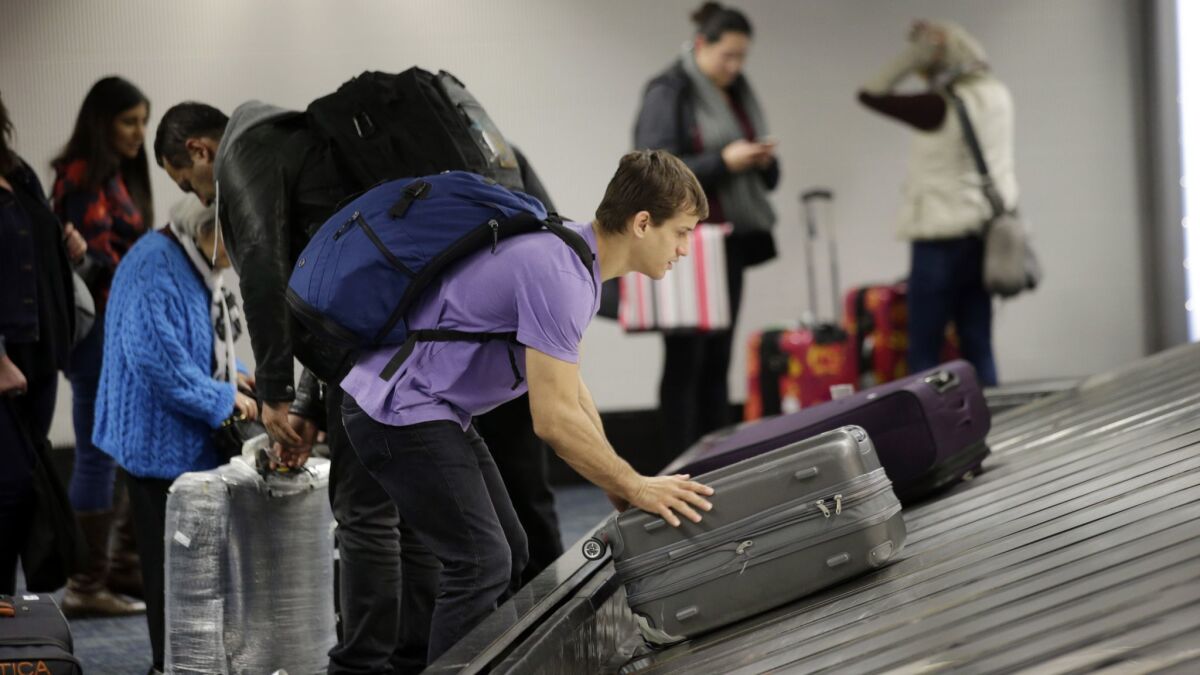 A traveler gathers his luggage at San Francisco International Airport. The nation's biggest airlines reported $15.5 billion in profits last year, including $4.6 billion in bag fees.