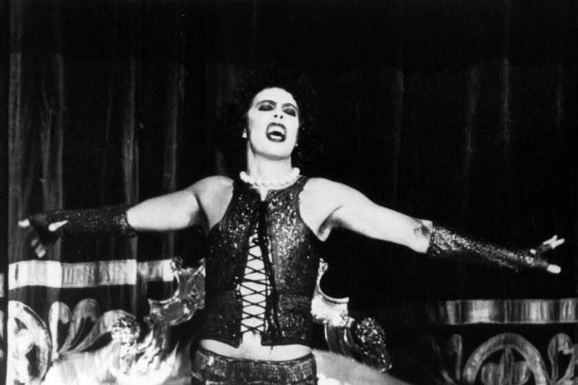 Tim Curry tosses off a cape while in characters as Dr. Frank-N-Furter
