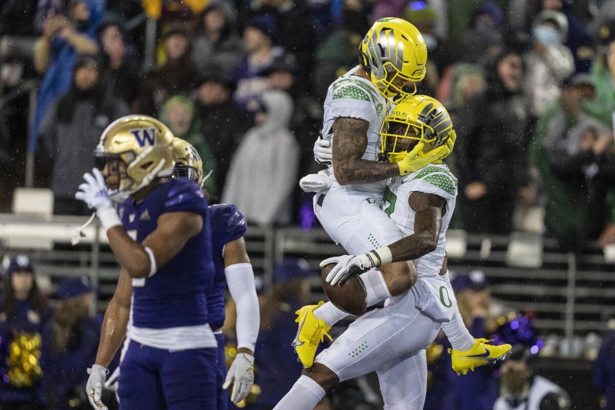 Oregon wide receiver Mycah Pittman, left, and wide receiver Devon Williams, right, celebrate a touchdown reception by Williams during the first half of a NCAA college football game against Washington, Saturday, Nov. 6, 2021, in Seattle. (AP Photo/Stephen Brashear)