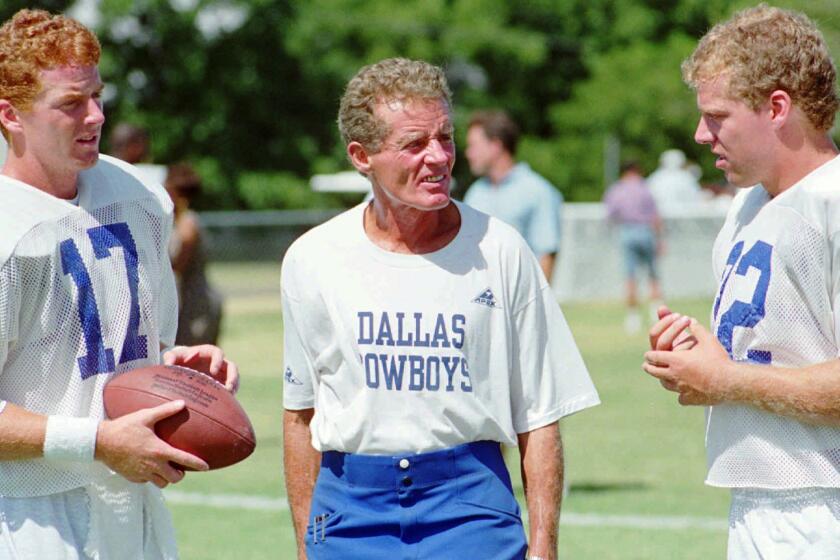 Jim Garrett, center, speaks with his sons Jason, left, and Judd during a Dallas Cowboys training camp session in July 1993.