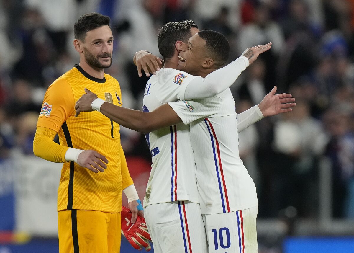 France's goalkeeper Hugo Lloris, left, Theo Hernandez and France's Kylian Mbappe celebrate at the end of the UEFA Nations League semifinal soccer match between Belgium and France at the Juventus stadium, in Turin, Italy, Thursday, Oct. 7, 2021. France won the match 3-2. (AP Photo/Luca Bruno)