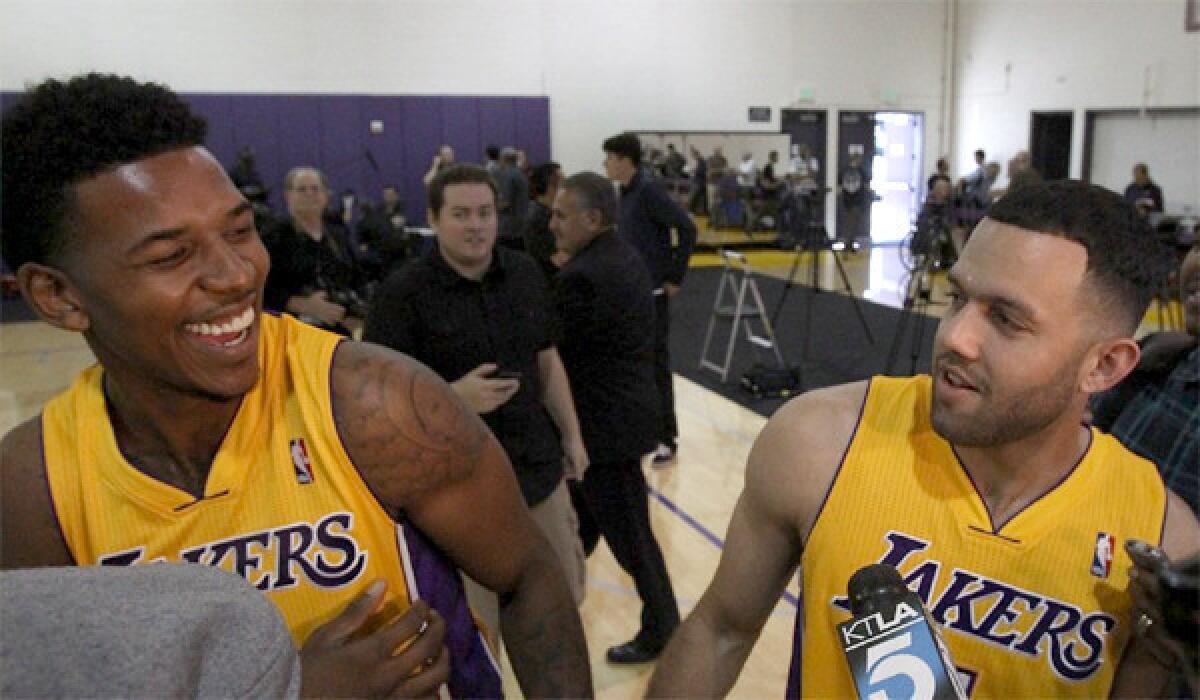 Lakers guards Nick Young, left, and Jordan Farmar, right, share a light moment during media day at the Lakers' training facility Saturday.