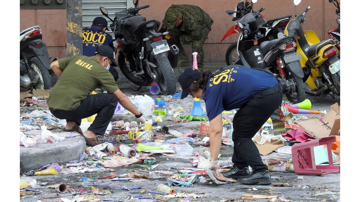 Police officers investigate at the site of an explosion outside a shopping mall in Cotabato on the southern island of Mindanao in the Philippines.