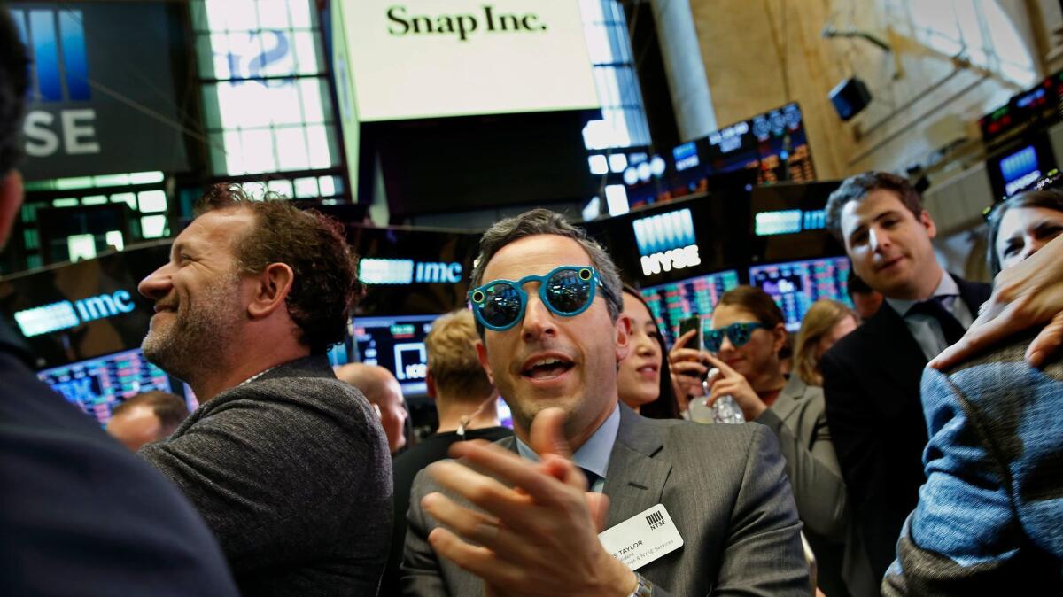 Wearing spectacles by Snap Inc., Chris Taylor, a vice president of the New York Stock Exchange, celebrates the company's stock listing.