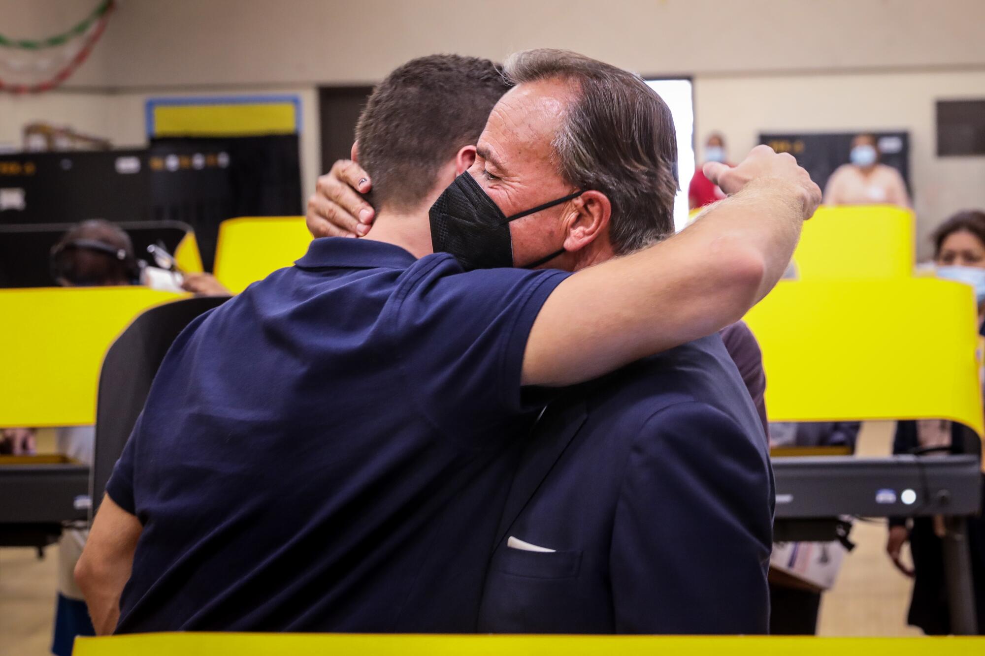 Rick Caruso stops to hug his son Justin.