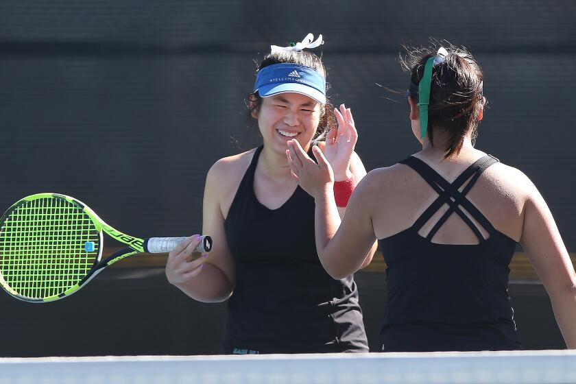 Sage Hill number one doubles team Madison Dao and Julia Yuen, from left, celebrate a tough point in doubles match against St. Margaret’s, in a San Joaquin League match at Saddleback College on Wednesday.