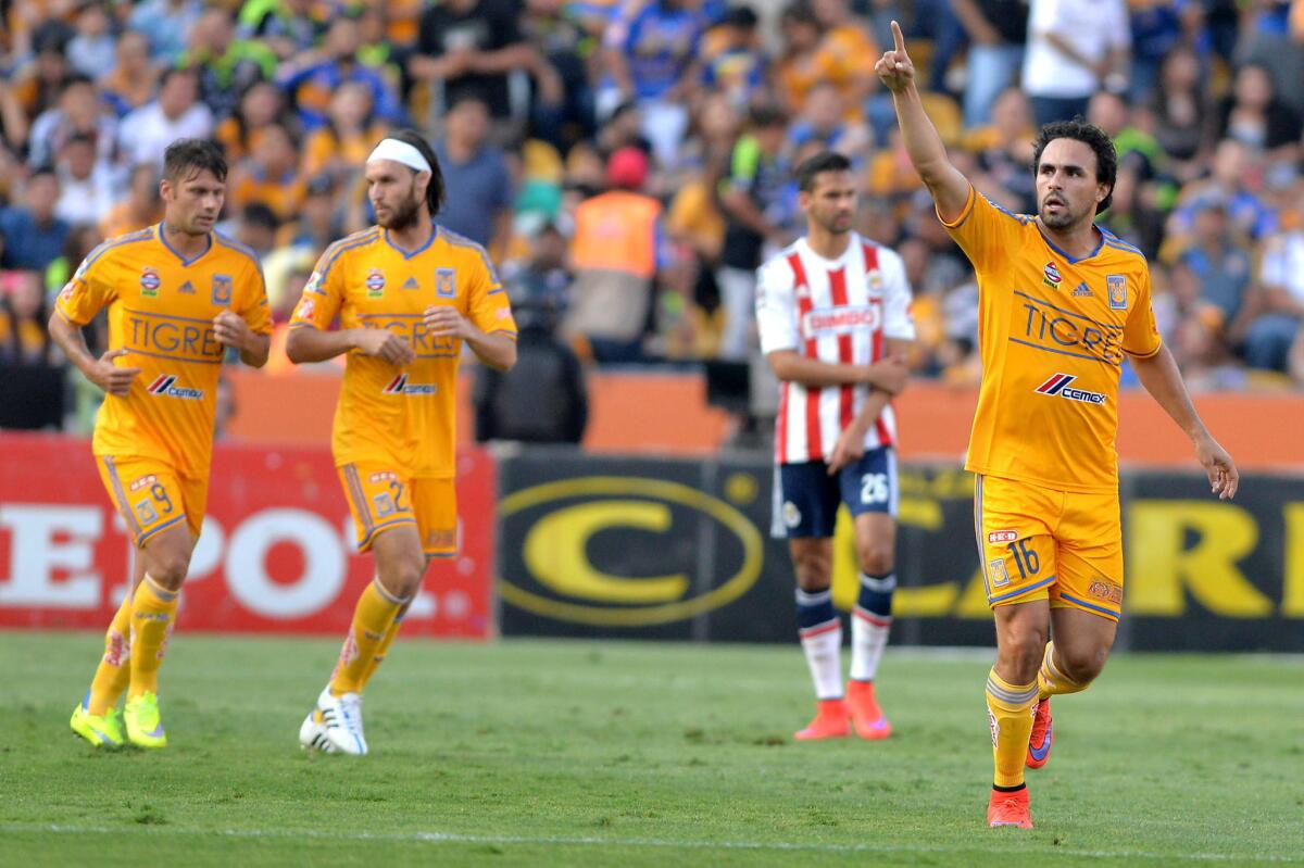 Enrique Esqueda (der) de Tigres festeja su gol sobre las Chivas.