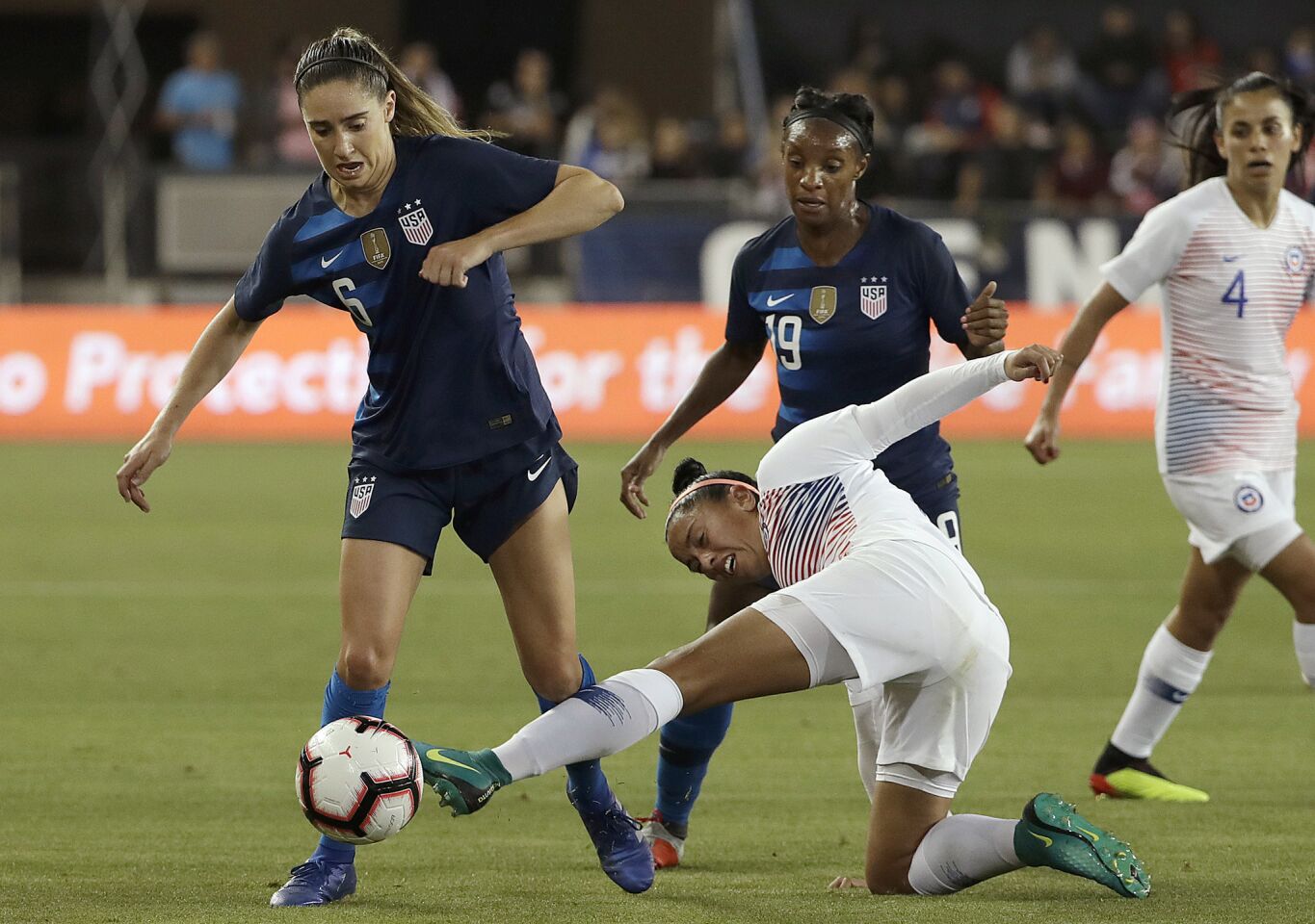 Chile's Claudia Soto, bottom, tries to kick the ball in front of United States' Morgan Brian, left, and Crystal Dunn, center, during the second half of an international friendly soccer match in San Jose, Calif., Tuesday, Sept. 4, 2018. (AP Photo/Jeff Chiu)