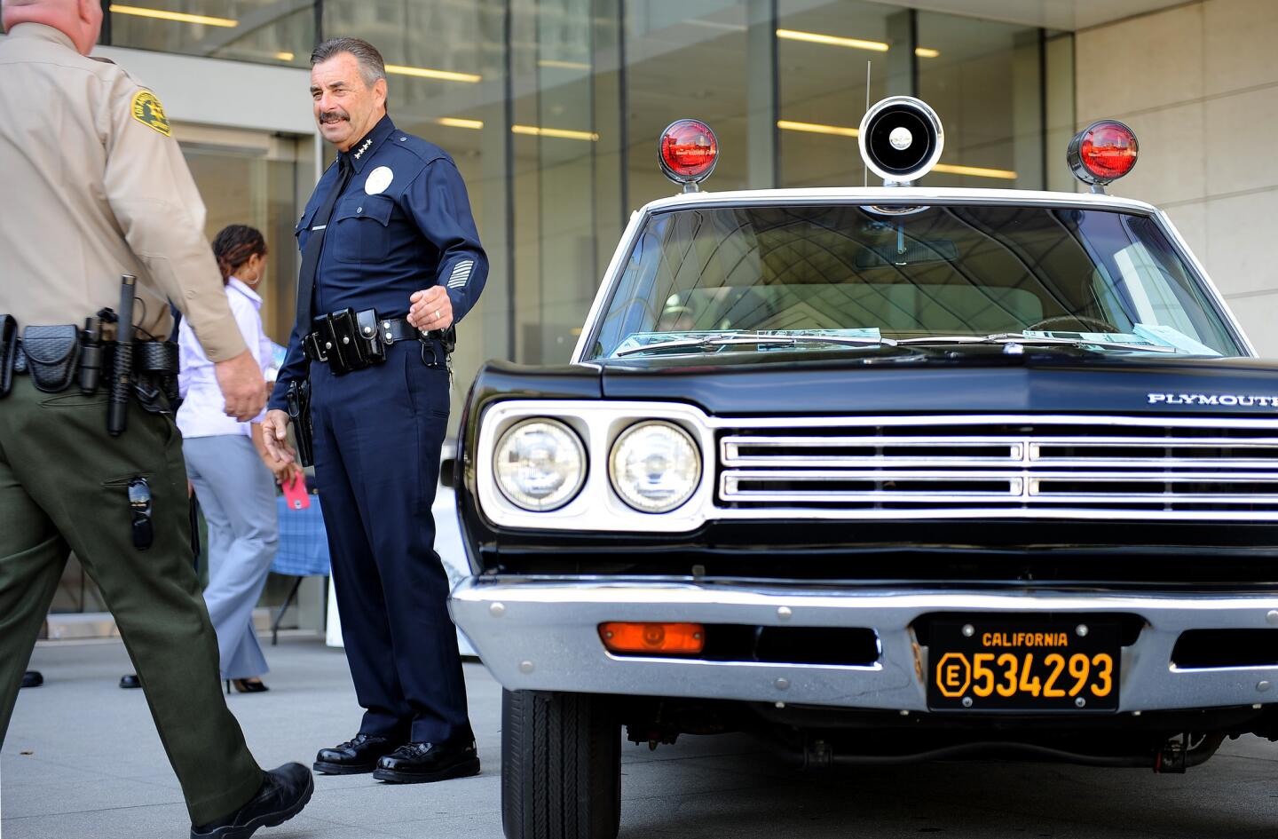 LAPD Chief Charlie Beck with a replica of the police car used in the TV show "Adam-12," on display at LAPD headquarters for a tribute to actor Martin Milner, who died Sept. 7.
