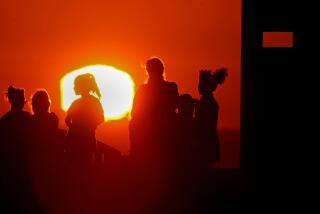 LONG BEACH, CALIF. - SEPT. 1, 2022. The blazing sun silhouettes visitors to Signal Hill after another hot day across Southern California. A brutal heatwave is expected to last through the Labor Day weekend. (Luis Sinco /. Los Angeles Times)