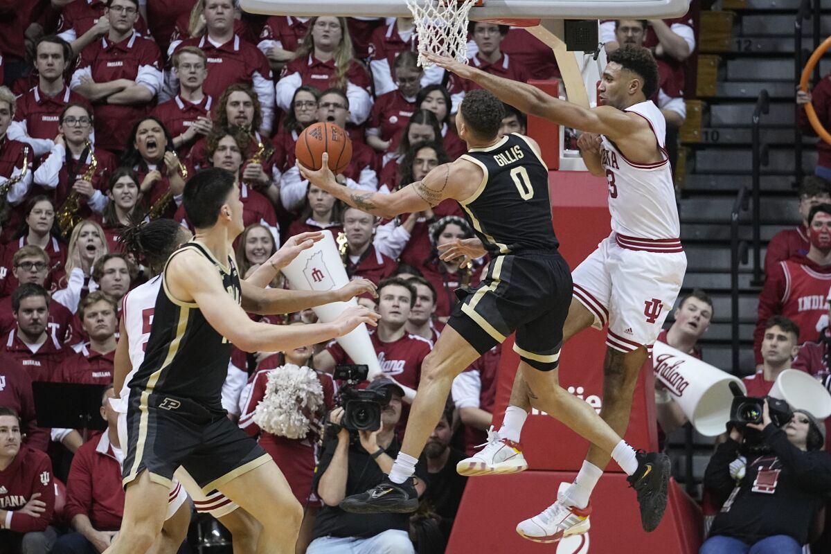 Purdue's Mason Gillis (0) puts up a shot against Indiana's Trayce Jackson-Davis (23) during the second half of an NCAA college basketball game, Saturday, Feb. 4, 2023, in Bloomington, Ind. (AP Photo/Darron Cummings)