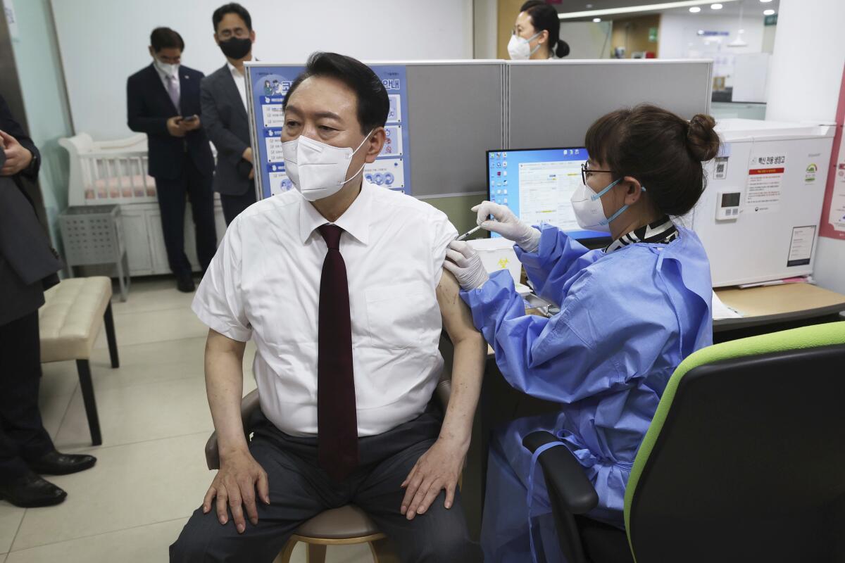 South Korean President Yoon Suk Yeol receives his fourth dose of the Pfizer COVID-19 vaccine at a public health center in Seoul, South Korea, Wednesday, July 13, 2022. (Seo Myung-gon/Yonhap via AP)
