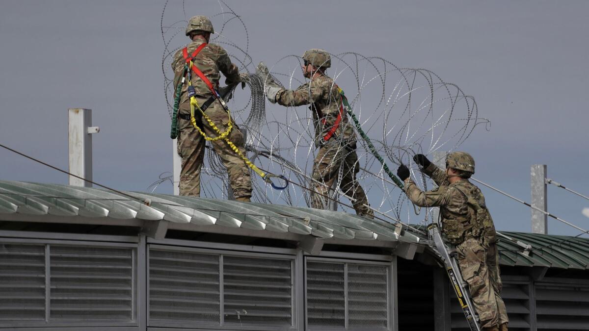 Members of the U.S.military place razor wire along the U.S.-Mexico border on the McAllen-Hidalgo International Bridge on Friday in McAllen, Texas.