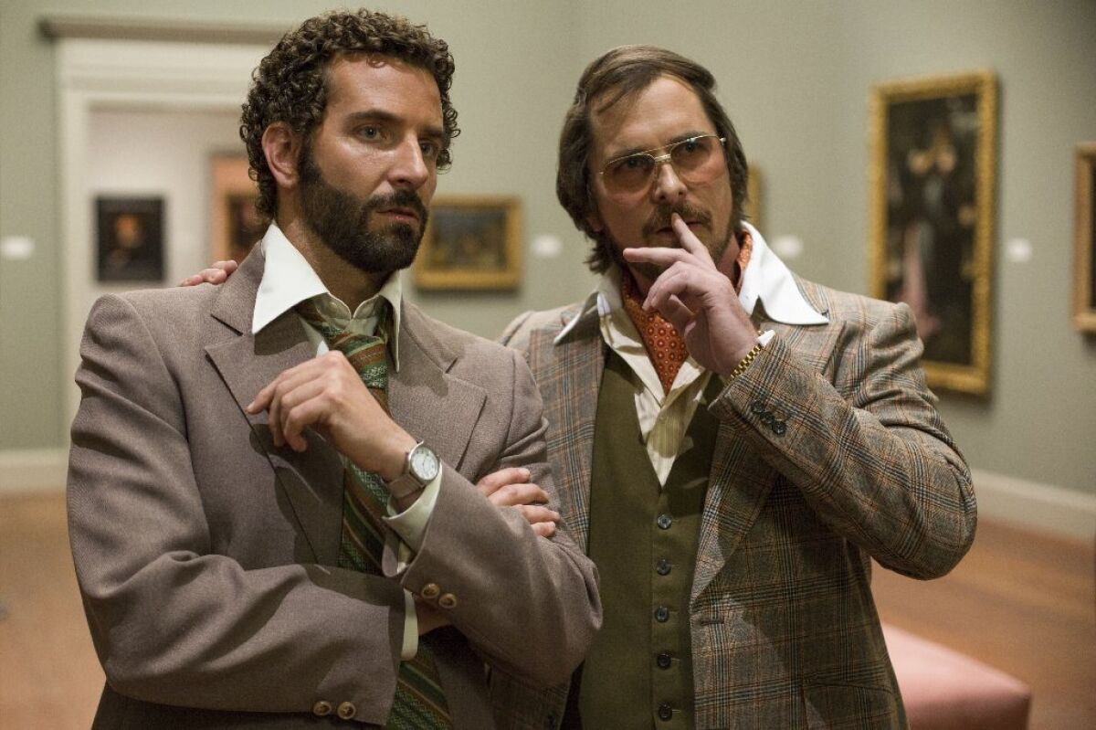 Bradley Cooper, left, as Richie DiMaso and Christian Bale as Irving Rosenfeld in "American Hustle."