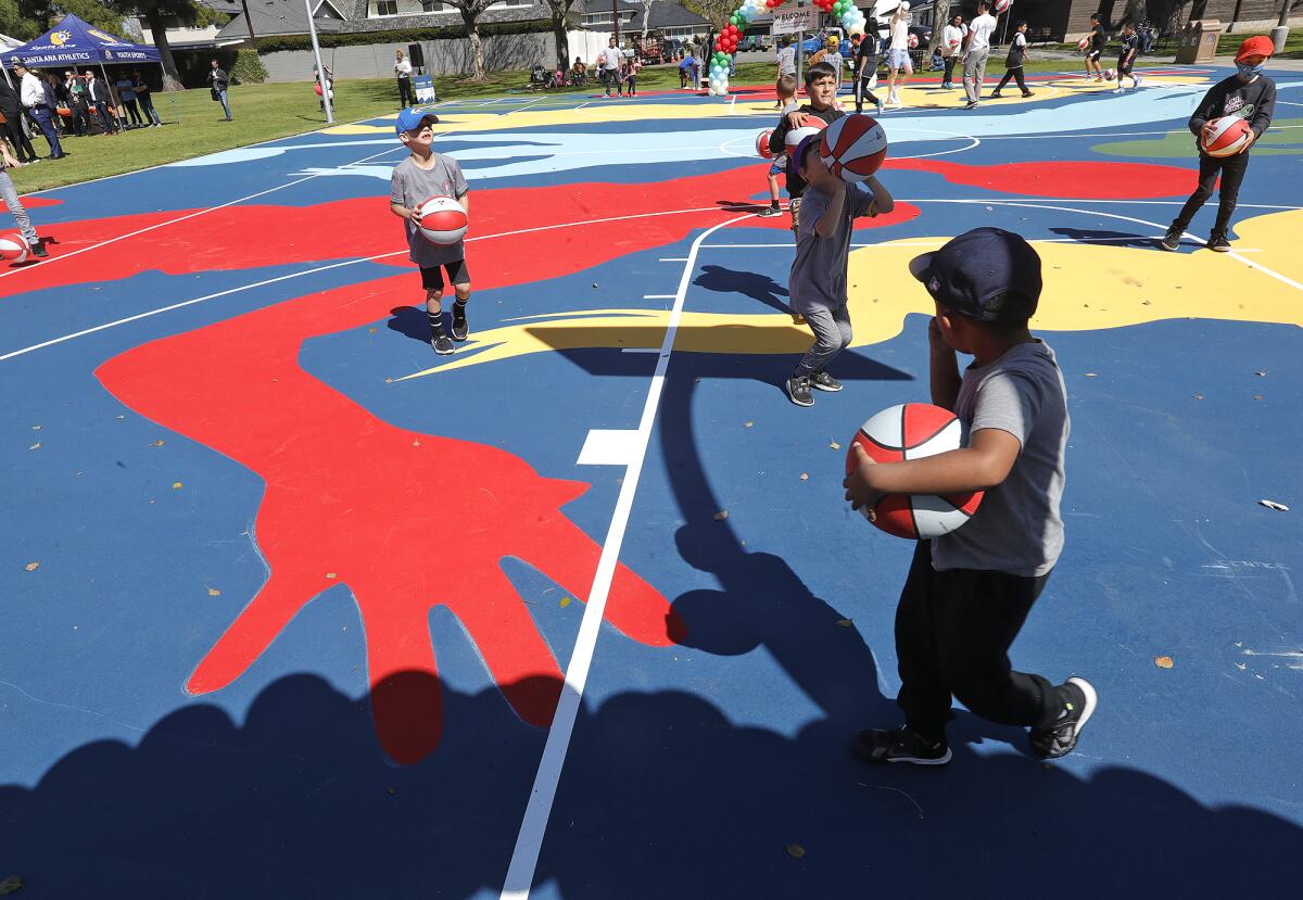 Kids take to the new "mural court" at Portola Park in Santa Ana on April 4. 