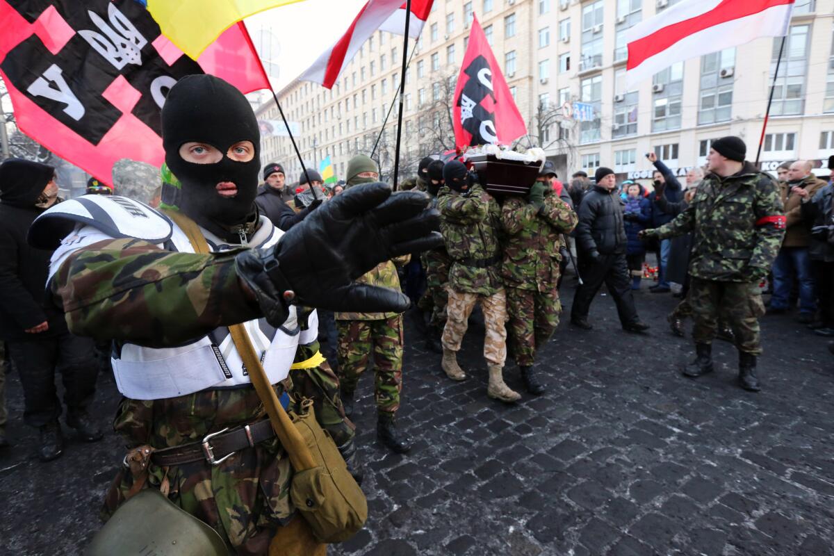 Ukraine protesters from a nationalist organization carry a casket with their dead comrade through the streets of central Kiev on Sunday. The opposition claims he was killed by a sniper.