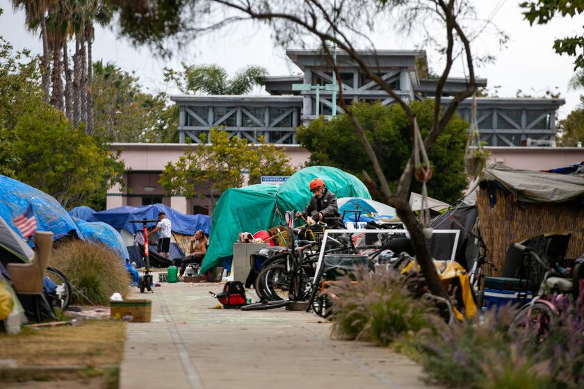 VENICE, CA - MAY 23: People gather and move about the homeless encampment outside Abbot Kinney Memorial Branch Library on Monday, May 23, 2022 in Venice, CA. (Jason Armond / Los Angeles Times)
