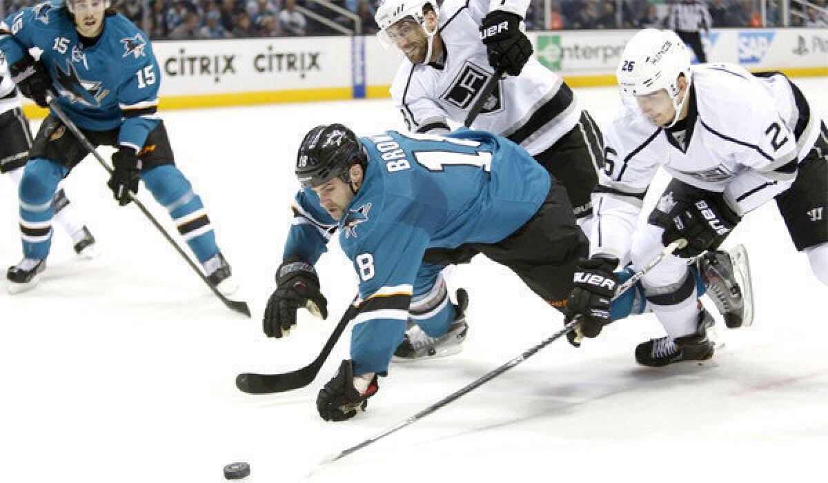 San Jose's Mike Brown and Slava Voynov battle for a loose puck during the first period of the Kings' 3-2 shootout loss to the Sharks on Wednesday at SAP Center.