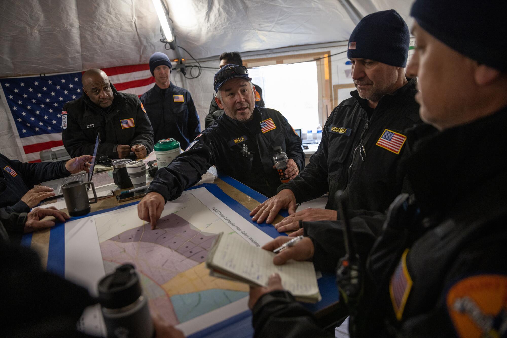 Members of the USAID Los Angeles County Fire Department Urban Search and Rescue team hold a meeting 