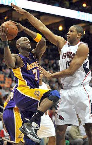 Hawks center Al Horford has Lakers forward Lamar Odom covered on a baseline drive in the first quarter Sunday afternoon.