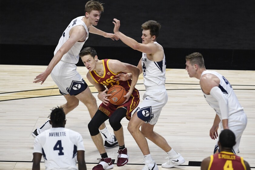 USC's Drew Peterson looks to pass between BYU's Matt Haarms and Brandon Averette.