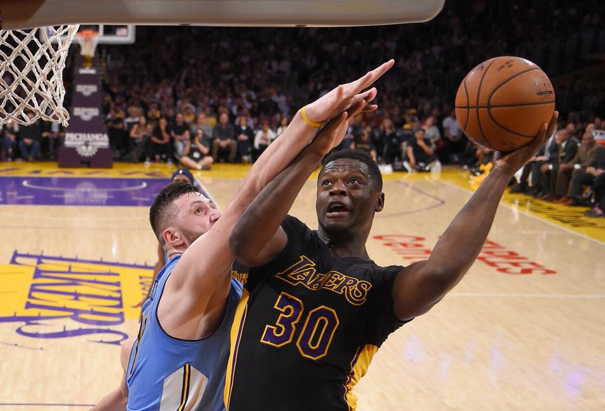 Lakers forward Julius Randle shoots as Nuggets center Jusuf Nurkic defends during the second half Friday night at Staples Center. Randle posted the first triple-double of his career in the game, though the Lakers lost.