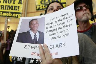 A woman displays a photo of Stephon Clark during a protest in Sacramento in 2018.