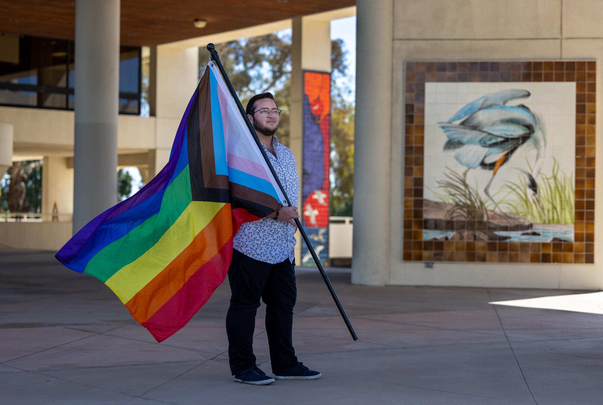 Kanan Durham, a trans man who is executive director of the non-profit Pride At The Pier, holds his Pride Flag.