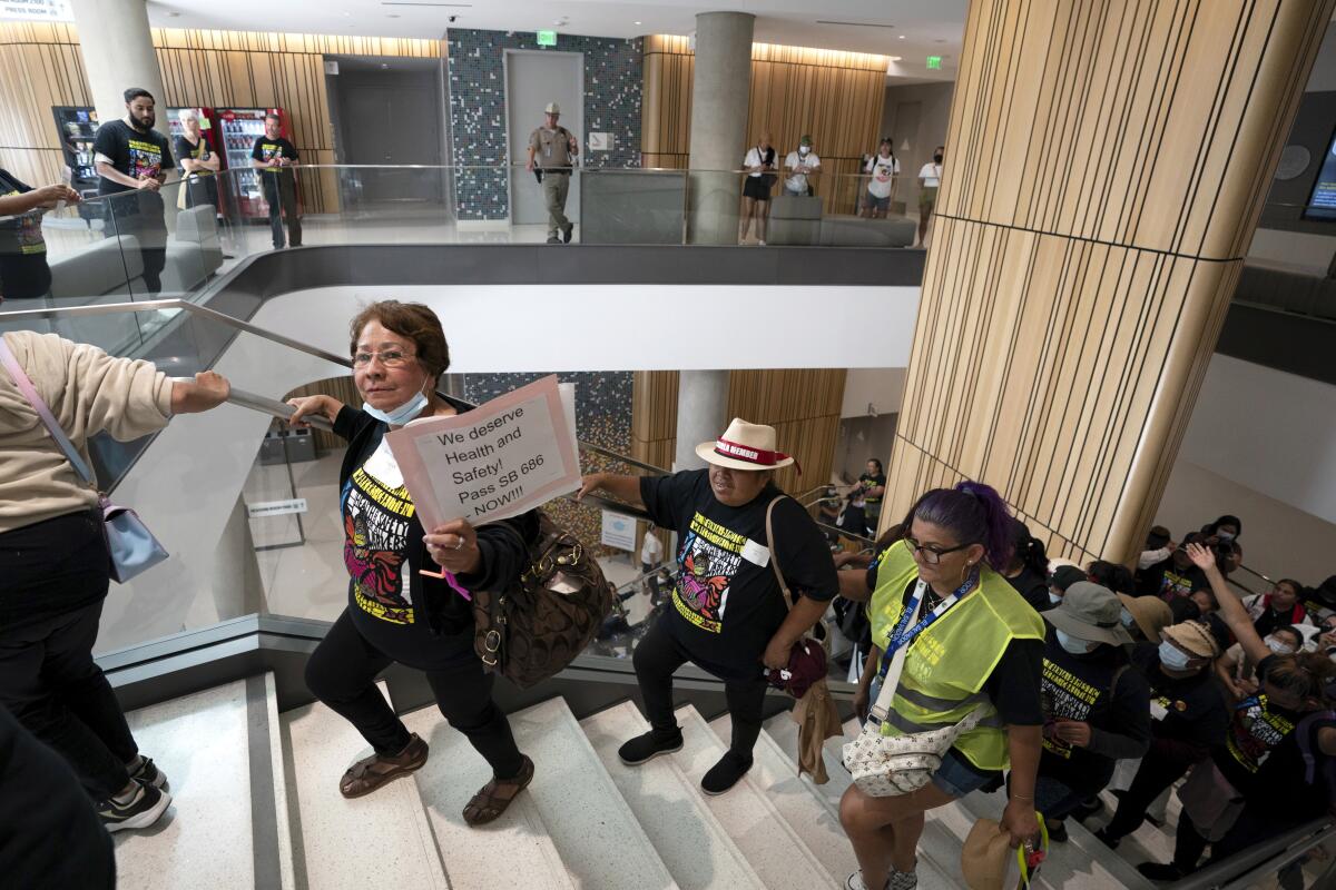 Workers hold signs and march through a government building.