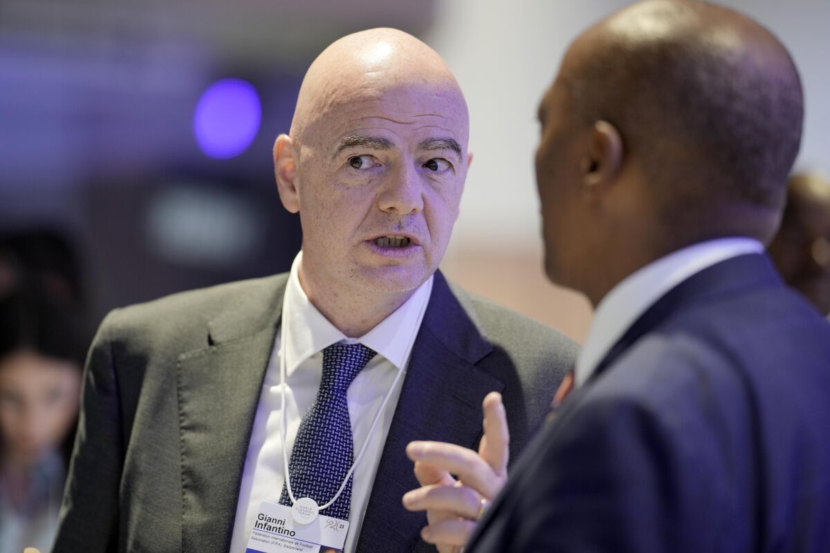 FIFA President Gianni Infantino, left, talks with South African mining businessman Patrice Motsepe, right, at the World Economic Forum in Davos, Switzerland, on Wednesday, Jan. 18, 2023. The annual meeting of the World Economic Forum is taking place in Davos from Jan. 16 until Jan. 20, 2023. (AP Photo/Markus Schreiber)
