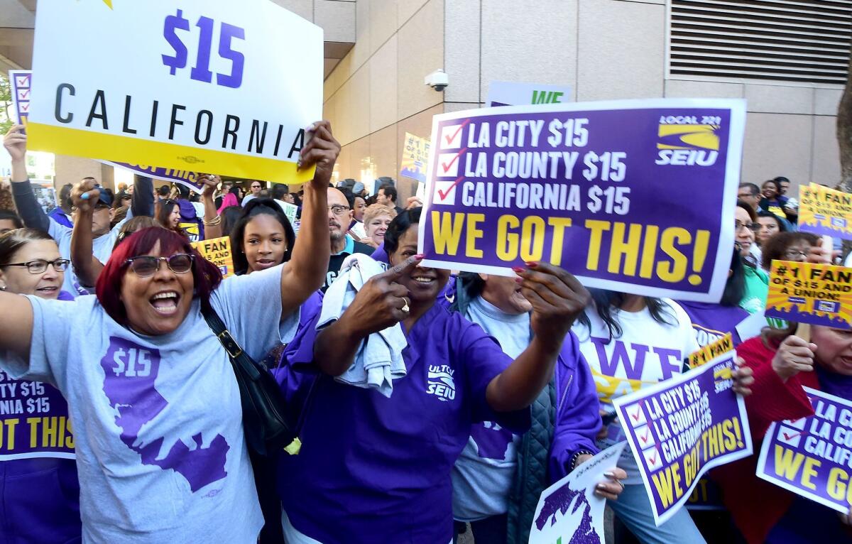 Workers celebrate outside the Ronald Reagan State Building in downtown Los Angeles, where California Governor Jerry Brown signed the bill that will raise the state's minimum wage to $15 an hour by 2022 while surrounded by supporters and politicians in Los Angeles, California on April 4, 2016.