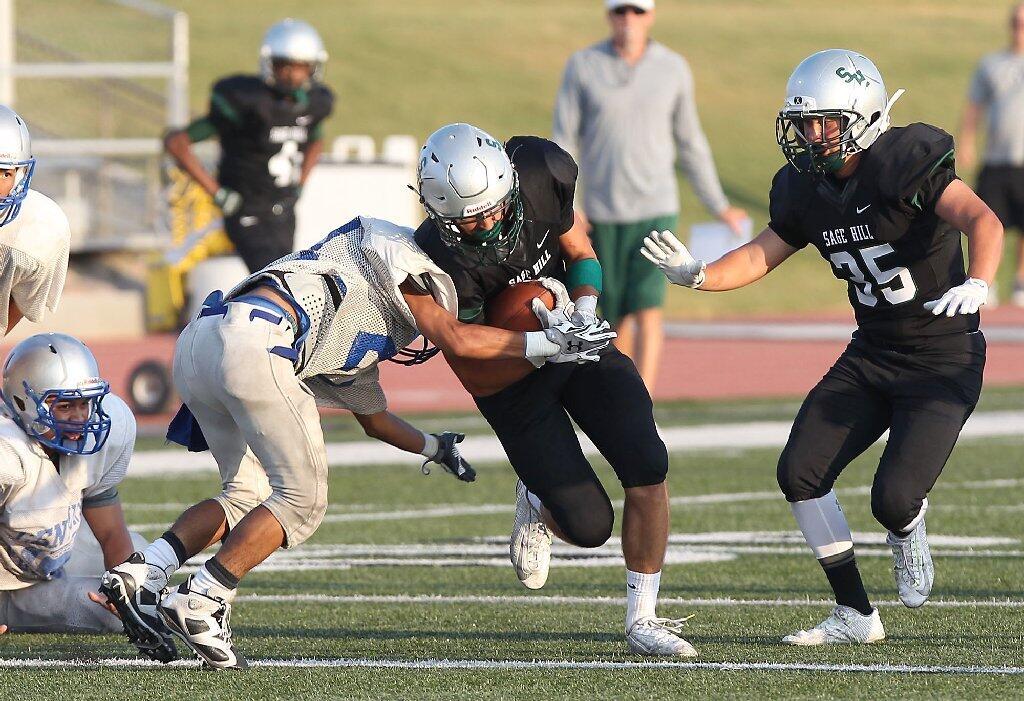 Sage Hill School's Jacob Copeland bounces off a would-be Century tackler during a scrimmage at Sage Hill on Friday.